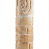Decorative round Jerusalem stone Mezuzah engraved with Kotel image, showcasing smooth and rough textures, in bright studio setting with soft reflection.
