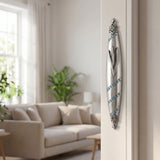 Hyper-realistic image of a polished pewter mezuzah with blue gemstones mounted on the right side of an interior doorway in a stylish home setting.