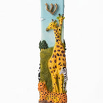Savannah Safari Fimo Mezuzah shown from the front as a mezuzah cover featuring a pale blue Fimo body with tall yellow giraffes, a zebra, spotted animals, green scenery and a gold-colored Hebrew Shin beneath decorative brass fittings, presenting a detailed Judaica design for a Jewish home doorway