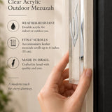 Clear acrylic mezuzah cover displayed vertically on a front doorpost, showing its large seven-inch scale and transparent rectangular body