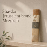 Handcrafted Jerusalem stone mezuzah case with Hebrew inscription, natural layered stone in warm tones, on a modern neutral background.