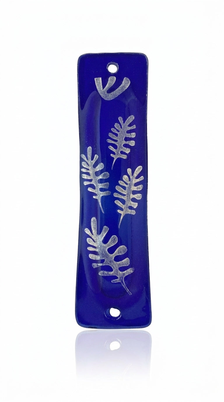 Silver glass mezuzah with intricate engraved details, Hebrew letters, and decorative motifs, mounted on a white background with a soft reflection.