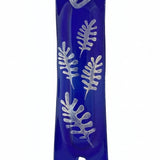 Silver glass mezuzah with intricate engraved details, Hebrew letters, and decorative motifs, mounted on a white background with a soft reflection.