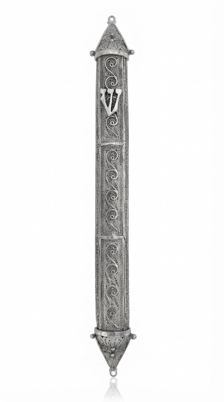 Large handcrafted sterling silver mezuzah with intricate filigree and transparent design, showcasing Hebrew script and decorative motifs, on a white studio background with subtle reflection.