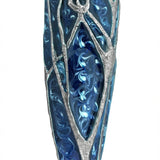 Detailed pewter mezuzah featuring a stylized tree of life in shades of blue, with a white background and soft reflection for a polished studio look.