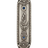 Petite Moroccan style pewter Mezuzah with Hebrew letters, decorative motifs, minor surface details and a white studio background with a soft reflection.