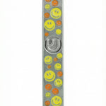 Vibrant yellow and orange smiley face pewter mezuzah, 5 inches tall, with Hebrew initials, decorative motifs, on a white studio background with light reflection.