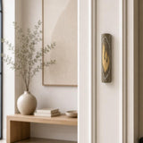 Gray Jerusalem stone mezuzah with gold Shin letter mounted on a residential doorpost.