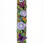 Uplifting pewter mezuzah decorated with dewy violet blossoms, fluttering butterflies, and a hidden ladybug, with a white studio background and soft reflection.