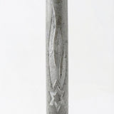 Gray Jerusalem stone mezuzah with engraved Hebrew letters and decorative motifs, displayed on a bright white studio background with soft reflection.