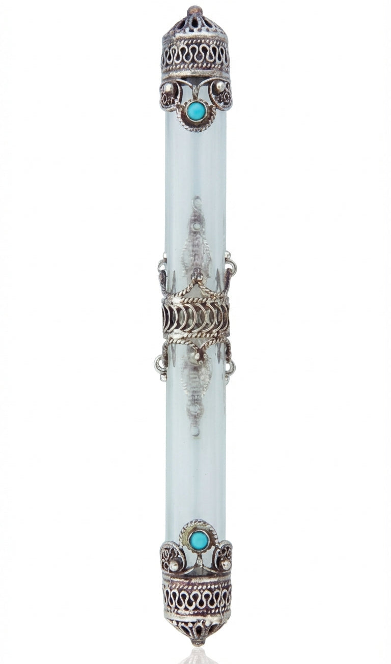 Sterling silver crown mezuzah with turquoise stone centerpieces, surrounded by a silver band, resting on a white studio surface with light reflection.