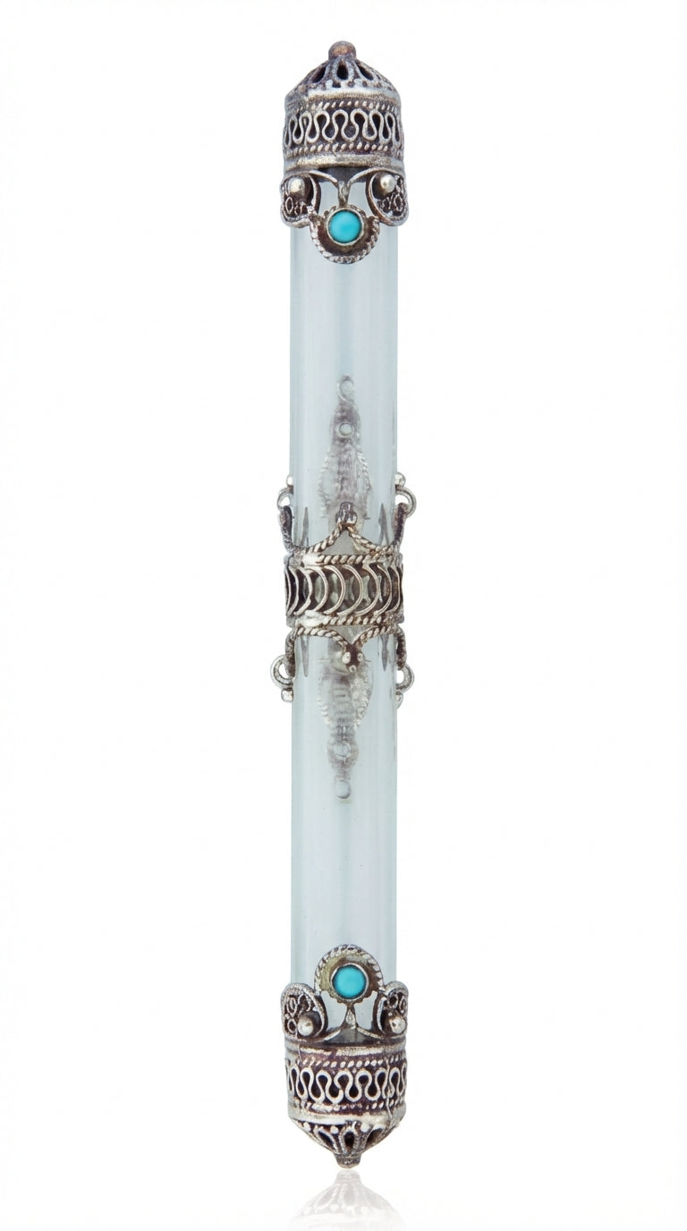 Sterling silver crown mezuzah with turquoise stone centerpieces, surrounded by a silver band, resting on a white studio surface with light reflection.