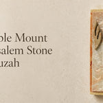 Temple Mount Jerusalem stone mezuzah case mounted vertically beside a doorway, featuring natural cream and warm rust-colored Jerusalem stone with a raised metallic Hebrew Shin. This traditional stone mezuzah brings the look and character of Jerusalem to a Jewish home, entrance, or interior doorway