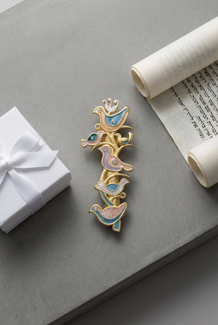 Artistic flat lay of The Shalom Birds Mezuzah on a concrete surface, with a gift box and scroll, highlighting craftsmanship and design.