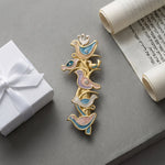 Artistic flat lay of The Shalom Birds Mezuzah on a concrete surface, with a gift box and scroll, highlighting craftsmanship and design.