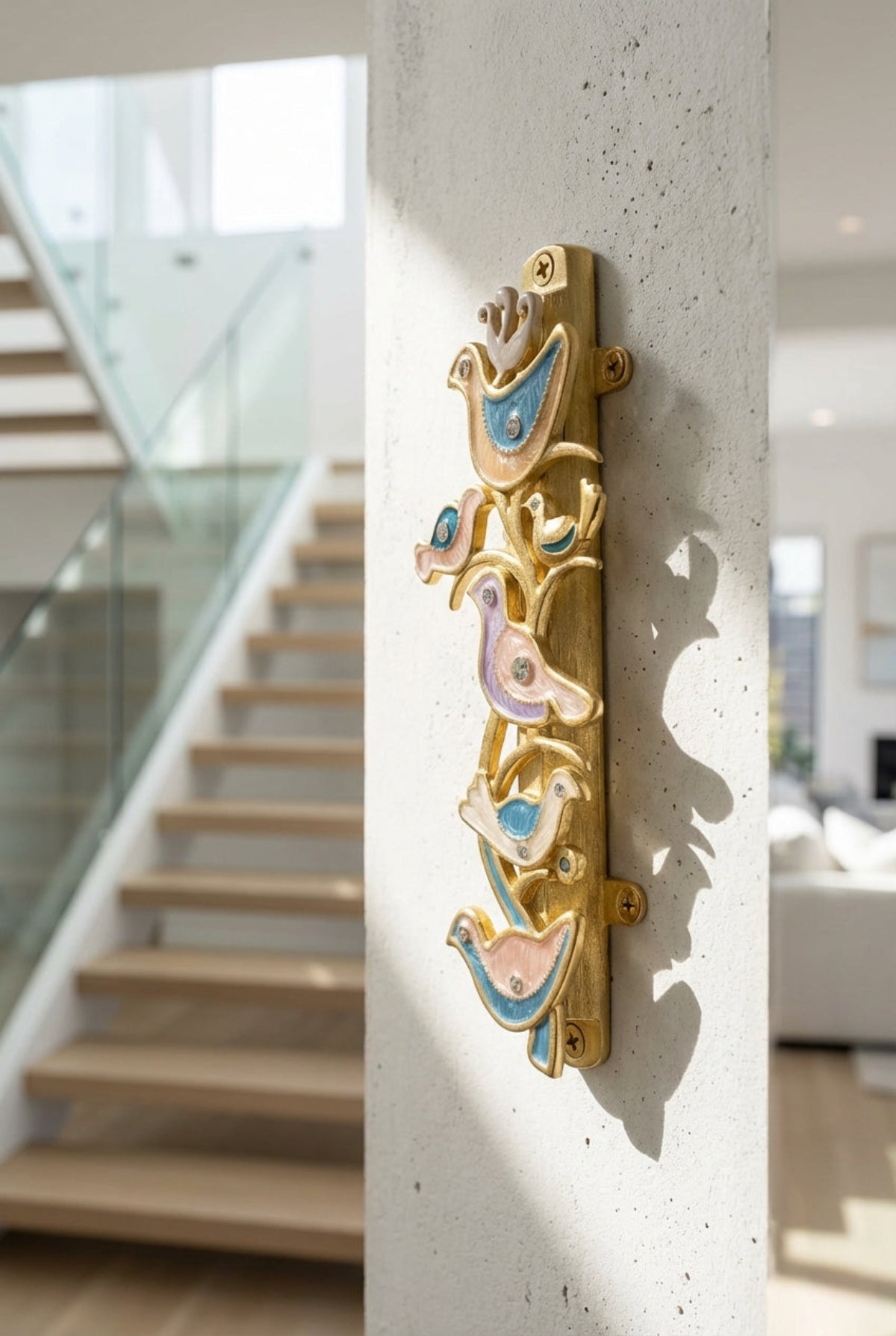 Side perspective of The Shalom Birds Mezuzah attached to a textured wall near a modern staircase, showing dimensions and details.