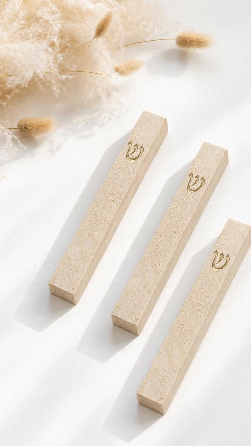 Three Classic Cream Gold Vein Jerusalem stone mezuzah cases arranged on a white surface, showing natural cream stone texture, warm mineral veining, and raised gold Shin details