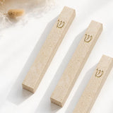 Three Classic Cream Gold Vein Jerusalem stone mezuzah cases arranged on a white surface, showing natural cream stone texture, warm mineral veining, and raised gold Shin details