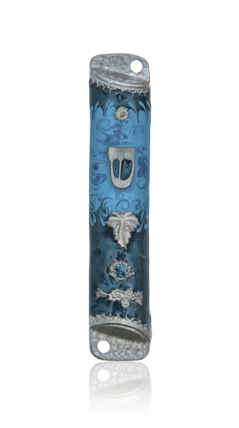 Pewter mezuzah with enamel paint, featuring a floating leaf on a blue background, displayed on a white studio surface with soft reflection.