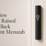 Timeless black cement mezuzah displayed against a minimalist background with a large raised silver-tone Shin, highlighting the matte black rectangular case, bold metallic contrast, and clean contemporary Judaica aesthetic