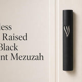 Timeless black cement mezuzah displayed against a minimalist background with a large raised silver-tone Shin, highlighting the matte black rectangular case, bold metallic contrast, and clean contemporary Judaica aesthetic