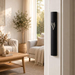 Timeless Raised Silver Shin Black Cement Mezuzah mounted vertically on a light residential doorpost, showing the bold matte black case and raised silver-tone Shin against a bright contemporary Jewish home interior