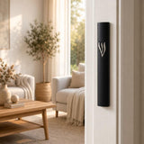 Timeless Raised Silver Shin Black Cement Mezuzah mounted vertically on a light residential doorpost, showing the bold matte black case and raised silver-tone Shin against a bright contemporary Jewish home interior