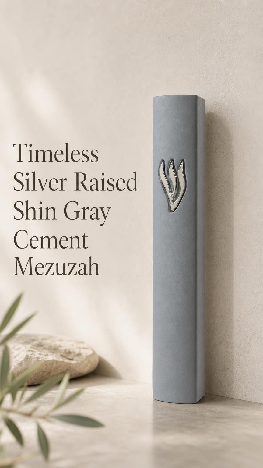 Timeless gray cement mezuzah displayed upright against a minimalist neutral background, featuring a large raised sculptural silver-tone Shin on the smooth gray face and a clean understated contemporary Judaica design