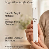 Person's hand holding an opaque white outdoor mezuzah case with a prominent silver Shin symbol.