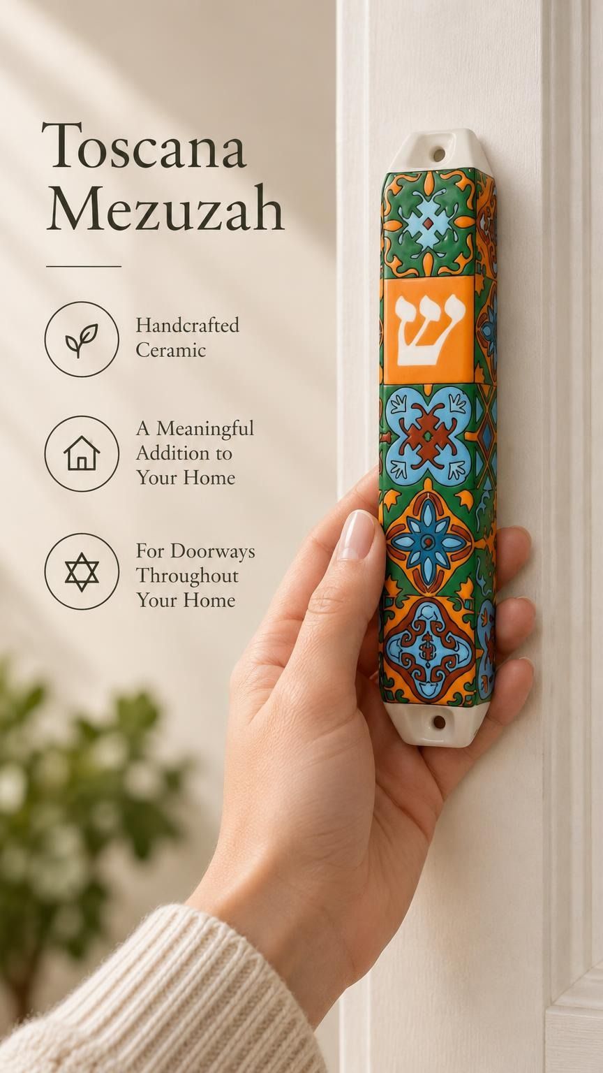 A person holding the colorful floral Toscana ceramic mezuzah with orange, green, and blue tile-like motifs and a white Shin.