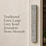 Handcrafted Jerusalem stone mezuzah case with carved Shin symbol, textured surface, and natural grey tones, mounted on a wall.