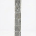 Handcrafted Jerusalem stone mezuzah with carved Shin symbol, textured surface, natural grey tones, and architectural presence for doorways.
