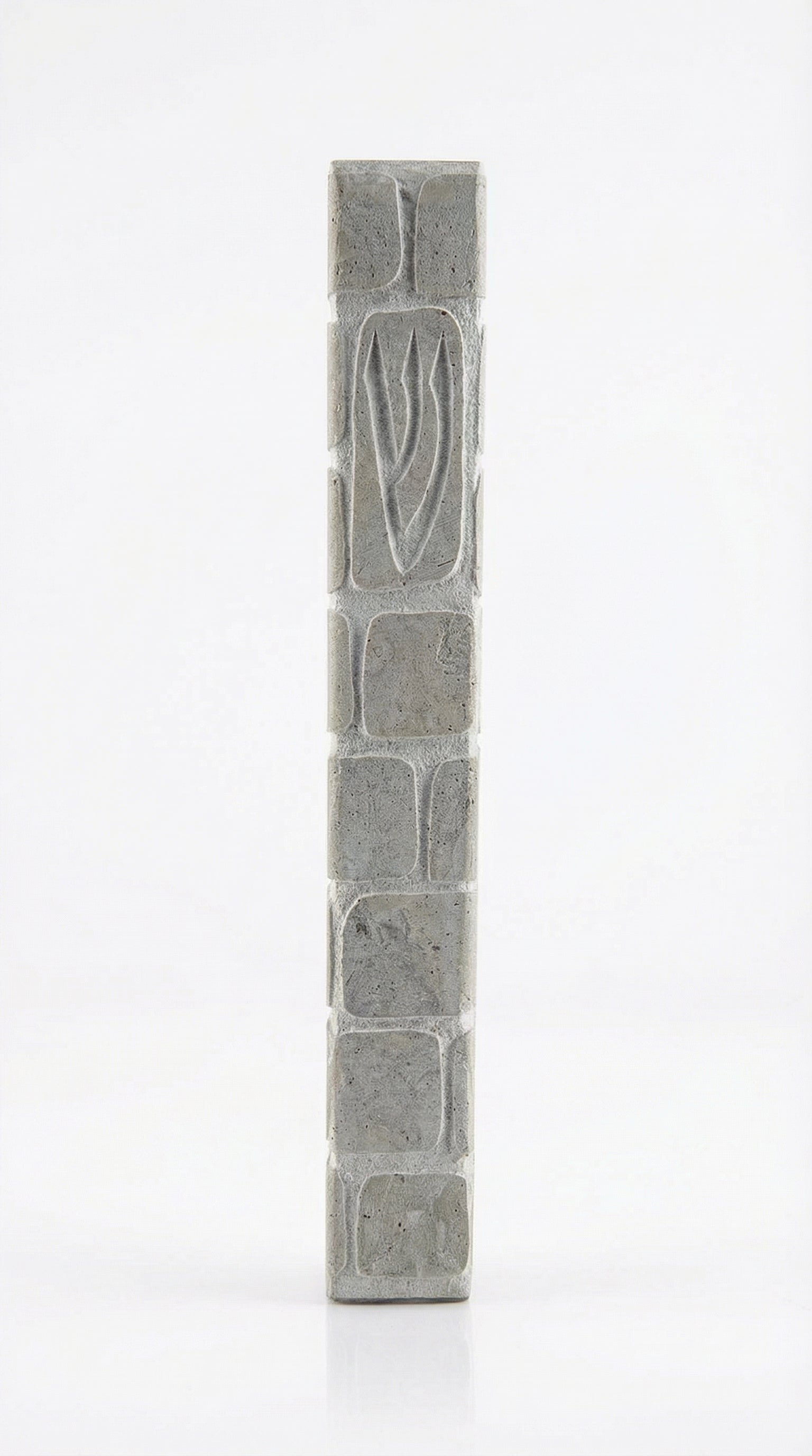 Handcrafted Jerusalem stone mezuzah with carved Shin symbol, textured surface, natural grey tones, and architectural presence for doorways.