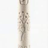 Cream Jerusalem stone Mezuzah with intricate design and Hebrew inscription, displayed vertically on a white studio surface with a soft reflection.