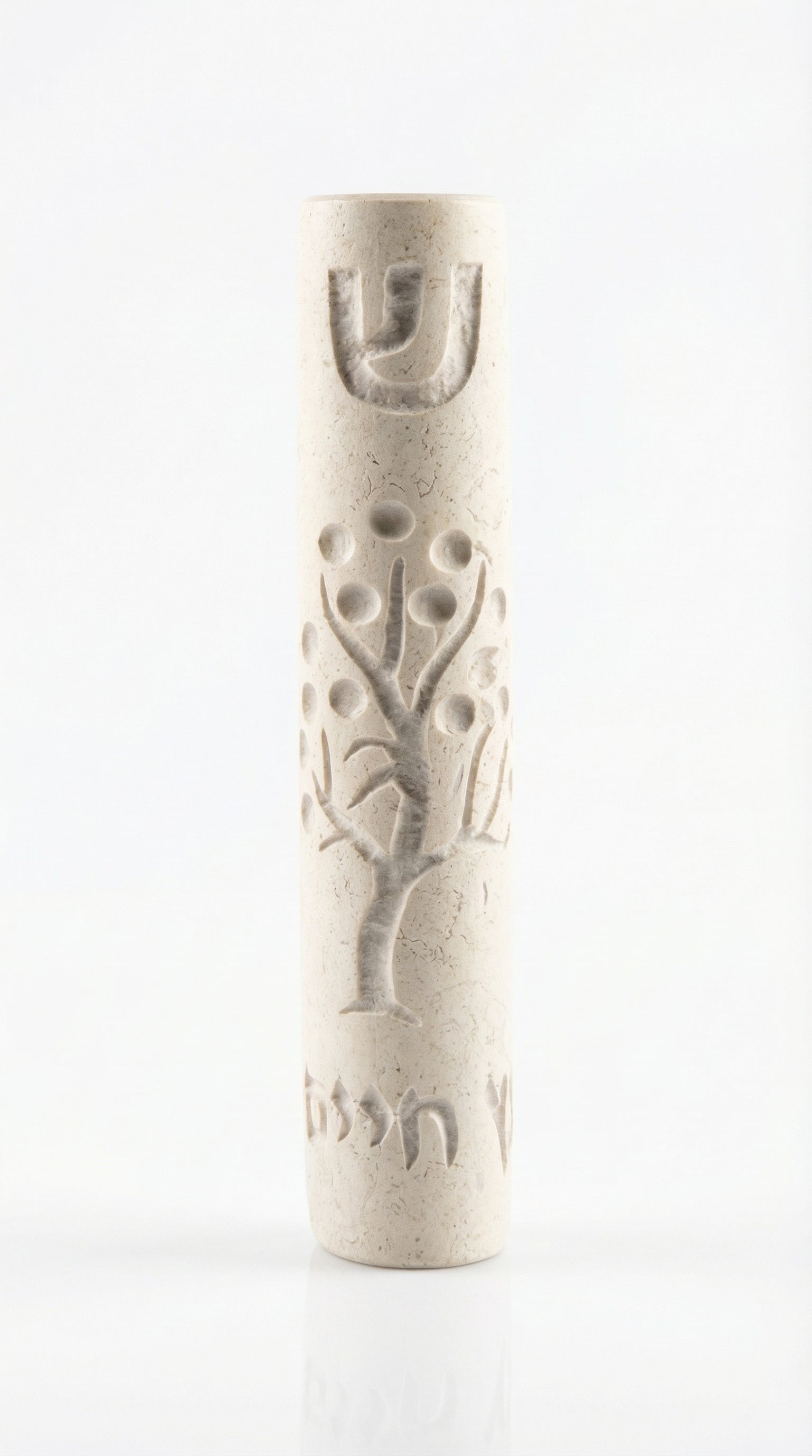 Cream Jerusalem stone Mezuzah with intricate design and Hebrew inscription, displayed vertically on a white studio surface with a soft reflection.