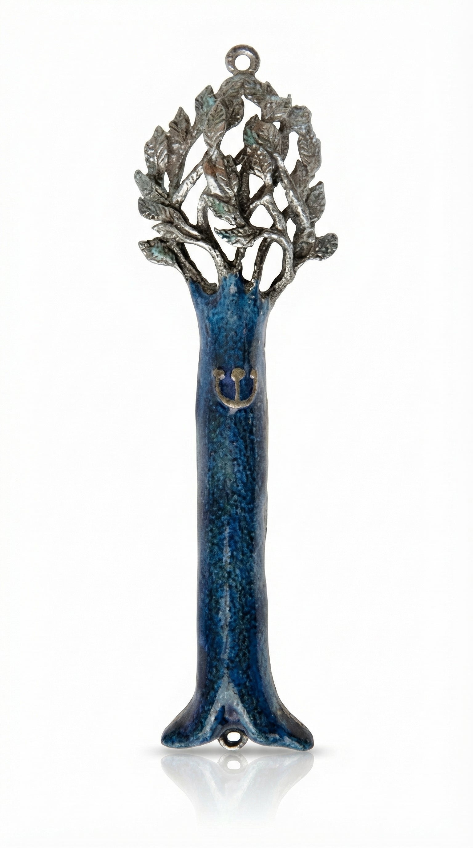 Pewter mezuzah with blue enamel depicting the tree of life, finely detailed and oriented vertically, on a white background with a subtle reflection.