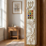 Twelve Jewels Dove Pearl pewter mezuzah case with gold Shin, jeweled Choshen-style panel, white dove, flowers, and pearl enamel ona doorframe in a home