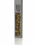 Gray cement mezuzah case with golden amber crystal and glass inlay reflecting champagne, honey, bronze, and a raised silver Shin