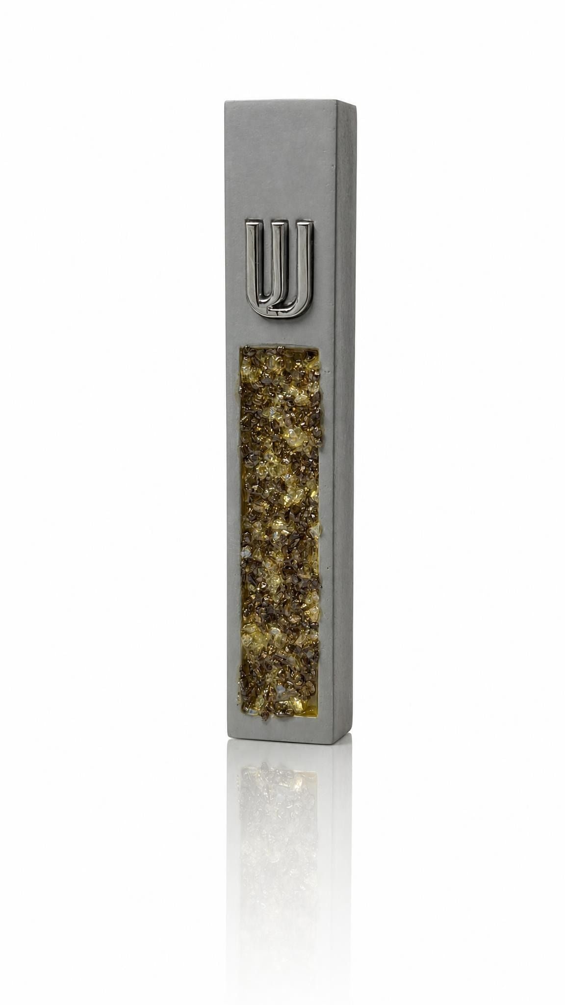 Gray cement mezuzah case with golden amber crystal and glass inlay reflecting champagne, honey, bronze, and a raised silver Shin