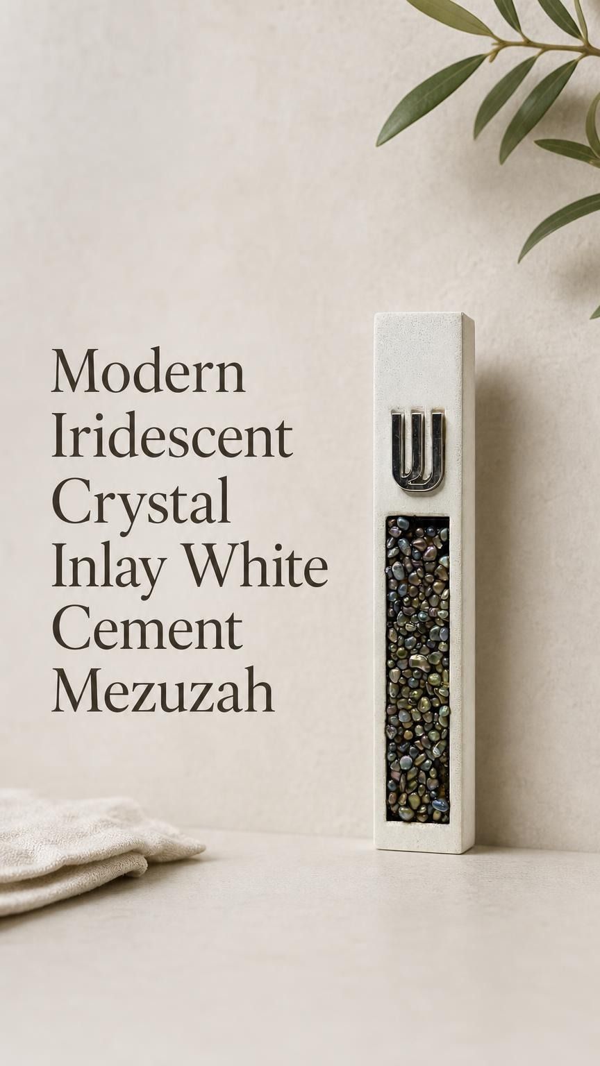 Close portrait of a unique modern white cement mezuzah case featuring a raised silver-tone Shin above a vertical panel of iridescent crystal and glass pieces with pearl, charcoal, bronze, green, and blue-gray reflections against a clean neutral backdrop