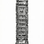 High-resolution image of a pewter Jerusalem Mezuzah with Hebrew engravings, on a white studio background with a soft reflection below.