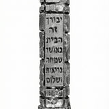 High-resolution image of a pewter Jerusalem Mezuzah with Hebrew engravings, on a white studio background with a soft reflection below.