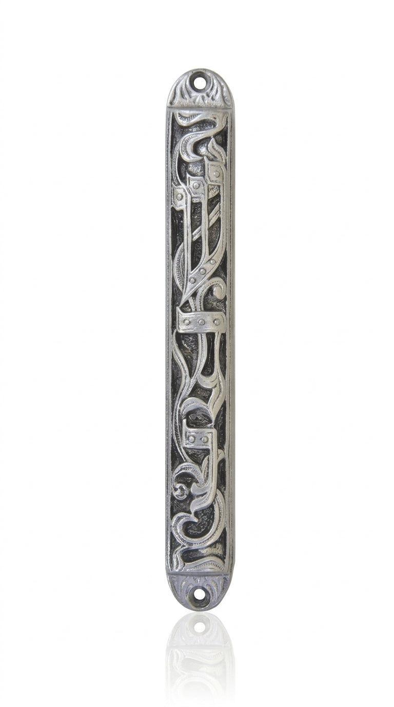 Elegant pewter mezuzah with Hebrew sha-dai and vine engravings, mounted on a white studio background with subtle reflection.