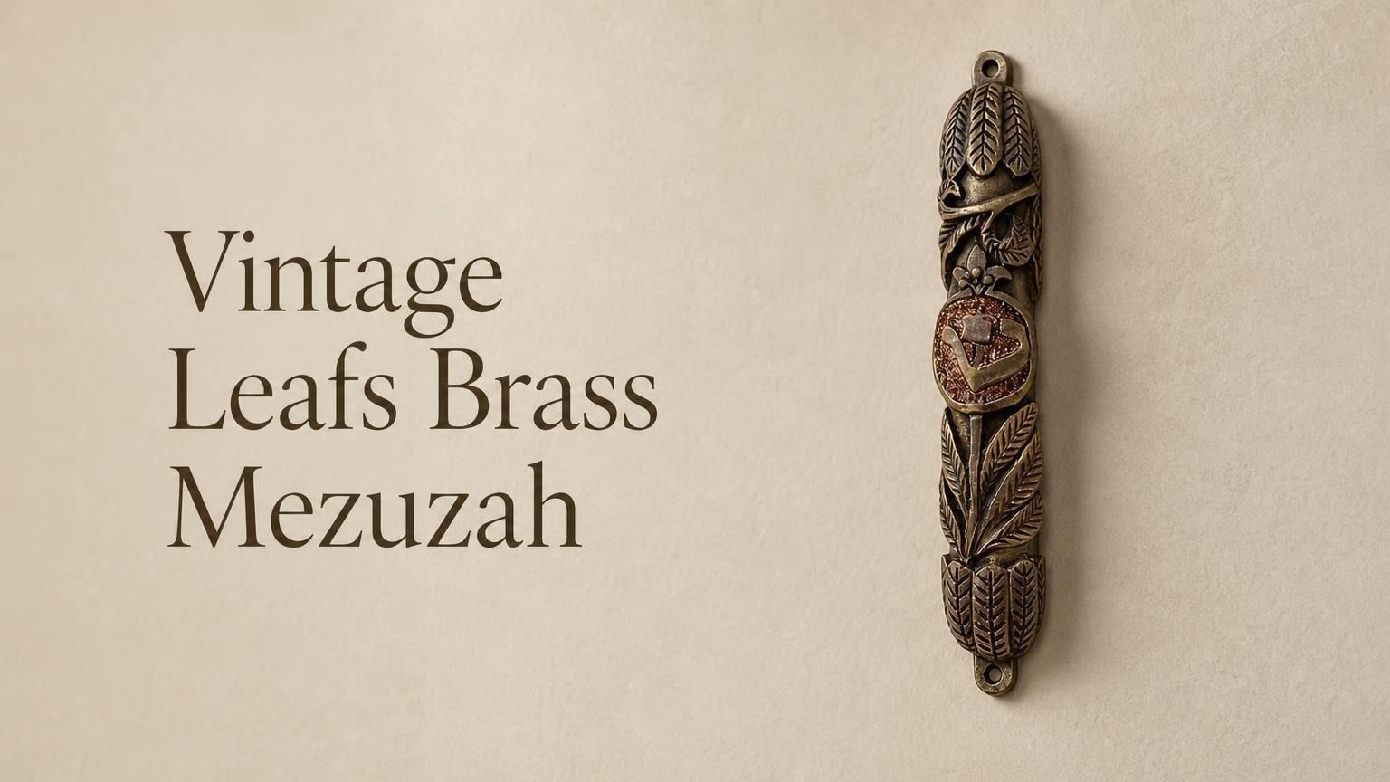Vintage Leafs brass mezuzah case mounted on a neutral wall, featuring an aged antique brass finish, deeply sculpted leaves and botanical details, and a raised Hebrew Shin medallion at the center. This traditional brass mezuzah case brings warm vintage Judaica character to a Jewish home, entryway, or interior doorway