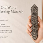 Hand holding vintage pewter mezuzah case with antique texture and symbolic medallions, showcasing old world charm and character.