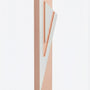 Modern Capital Shin pink aluminum mezuzah case on white with a soft pink body and a large angular silver Hebrew Shin