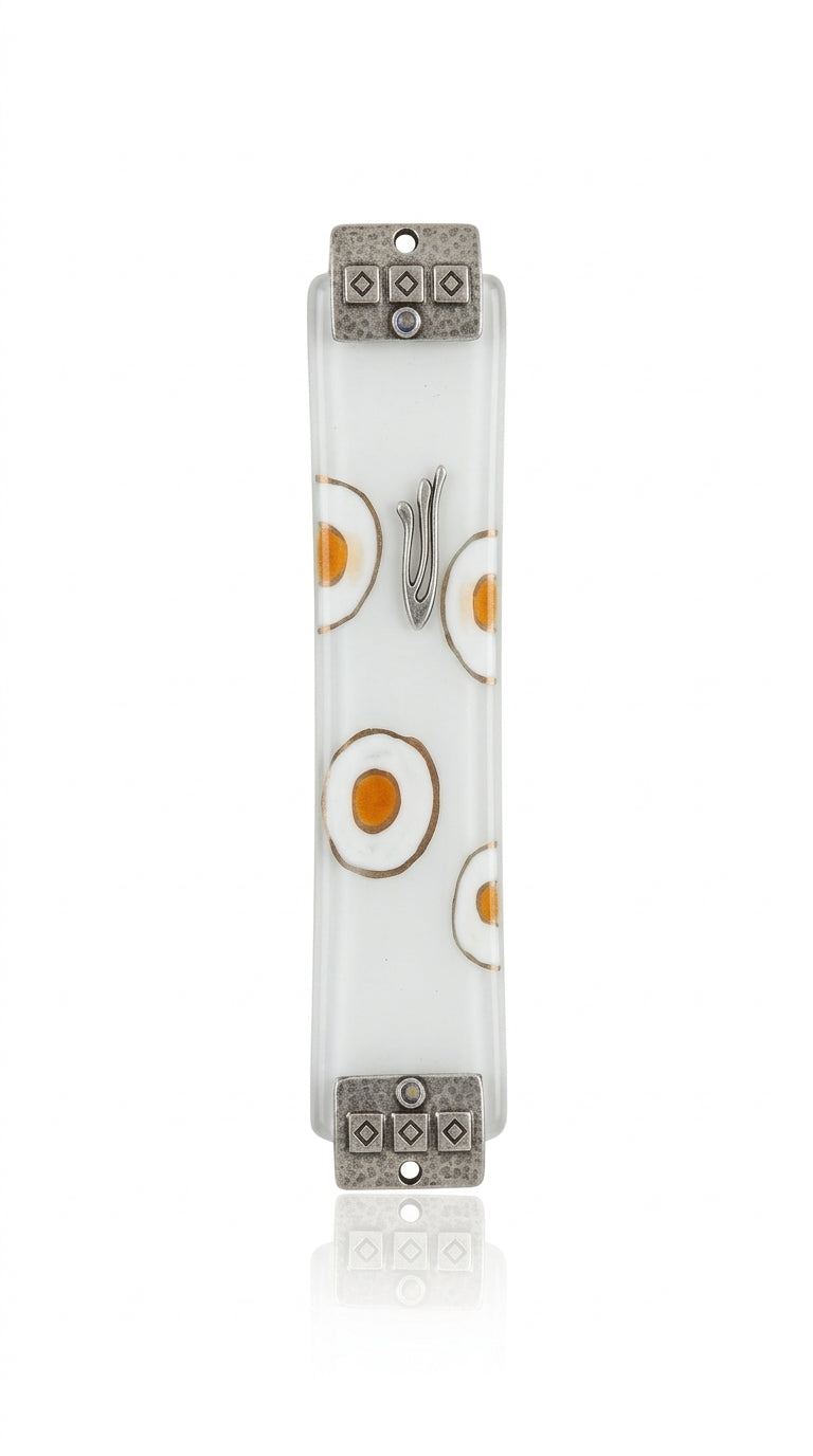 White fused-glass Mezuzah with hand-painted white and silver circles, textured silver metal accents at top and bottom, on a polished white surface.