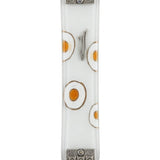 White fused-glass Mezuzah with hand-painted white and silver circles, textured silver metal accents at top and bottom, on a polished white surface.