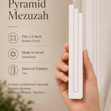 Person holding the modern white pyramid mezuzah with space for editorial text of mezuzah features