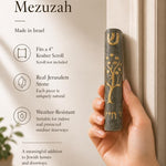 Person holding the exact source Jerusalem stone Tree of Life Gray mezuzah, showcasing its craftsmanship and materials in a natural setting for a premium product feature.